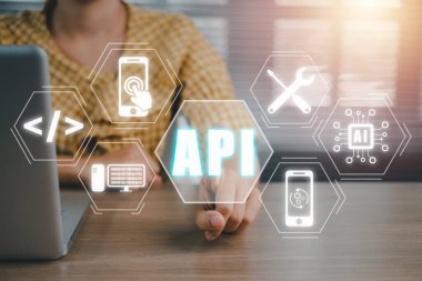 API, Uygulama Programlama Arayüzü, Ofis masasında VR ekran API simgesi olan dizüstü bilgisayar kullanan kadın, Yazılım geliştirme aracı, modern teknoloji, internet ve ağ konsepti.
