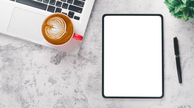 Office desk workplace with blank screen tablet, pen, laptop and cup of coffee, Top view flat lay with copy space.