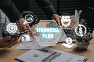 Finansal plan konsepti, gelir tablolarını ve grafiklerini analiz eden iş ekibi ve sanal ekranda finansal plan simgesi.