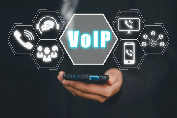 VoIP, Voice over IP Telecommunication concept, Business person hand using smartphone with VoIP icon on virtual screen.