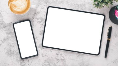 Beyaz ofis masası, beyaz ekran, akıllı telefon, tablet, kalem ve kahve ile işyeri..