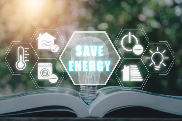 Energy saving concept, Light bulb on book with energy saving icon on virtual screen.