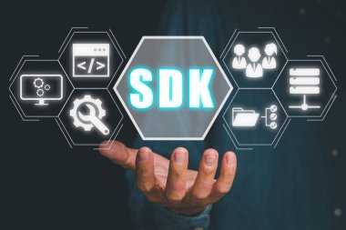 SDK - Yazılım geliştirme kiti programlama dili teknolojisi konsepti, Sanal ekranda SDK simgesini tutan kişi.