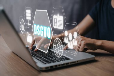 DSGVO Temel Veri Koruma Yönetmeliği, sanal ekranda DSGVO simgesi ile dizüstü bilgisayar üzerinde çalışan kişi.