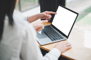 İki iş kadınının boş ekran dizüstü bilgisayarda çalışıp ekrana baktığı yakın plan görüntüler. Ofis çalışanı dizüstü bilgisayar kullanıyor..