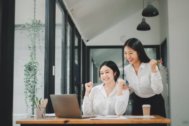 Güzel iki Asyalı kız dizüstü bilgisayarla kutlama yapıyor, başarı mutlu poz, E-ticaret, üniversite eğitimi, internet teknolojisi veya küçük işletme konsepti.