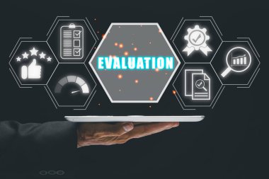 Değerlendirme kavramı, iş adamı sanal ekranda değerlendirme simgesiyle dijital tableti tutuyor.