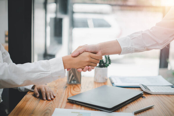 Two confident business person shaking hands during a meeting in the office, success, dealing, greeting and partner in sun light