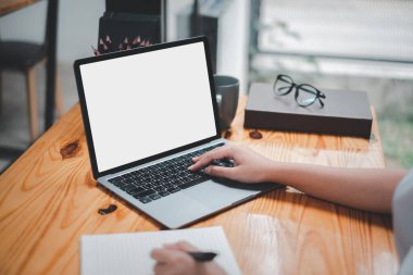 Ofiste çalışan, yazı yazan, ekrana bakan bir iş kadınının yakın plan görüntüsü. Ofis çalışanı dizüstü bilgisayar kullanıyor..