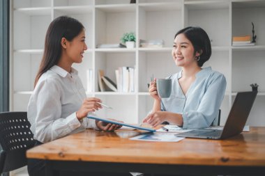 Gülümseyen çeşitli çalışanlar gülerek iş birliği yapıyor ofis ekibinin toplantısında bilgisayar üzerinde beyin fırtınası yapıyorlar. Mutlu çok ırklı iş adamları dizüstü bilgisayarda birlikte çalışıyorlar iş fikirlerini grup halinde tartışıyorlar..