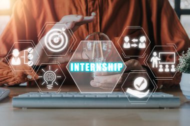 Internship concept, Business person hand holding light bulb with internship icon on virtual screen.
