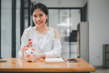 Domuz kumbarasının üstünde çekiç tutan kadın. Şok olmuş ve endişeli bir yüz ifadesi var..