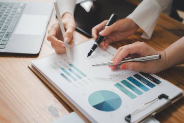 Group of business people analysis summary graph reports of business operating expenses and work data about the company's financial statements.	