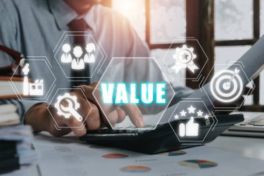 Değer kavramı: Sanal ekranda değer simgesi olan bir iş adamı hesap makinesi üzerinde çalışıyor.