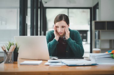 Yorgun iş kadını uykulu ve uzun süre masa başında oturmaktan sıkılmış ve ofis sendromu var.