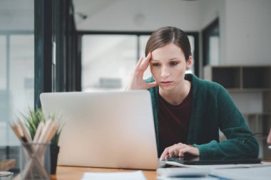 Yorgun iş kadını uykulu ve uzun süre masa başında oturmaktan sıkılmış ve ofis sendromu var.