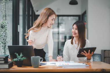 Female operations manager holds meeting presentation for a team of economists. Asian woman uses business paper with Growth Analysis, Charts, Statistics and Data.	