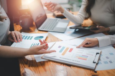 Group of business people analysis summary graph reports of business operating expenses and work data about the company's financial statements.	