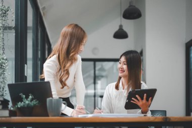 Gülümseyen çeşitli çalışanlar gülerek iş birliği yapıyor ofis ekibinin toplantısında bilgisayar üzerinde beyin fırtınası yapıyorlar. Mutlu çok ırklı iş adamları dizüstü bilgisayarda birlikte çalışıyorlar iş fikirlerini grup halinde tartışıyorlar..