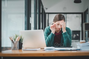 Yorgun iş kadını uykulu ve uzun süre masa başında oturmaktan sıkılmış ve ofis sendromu var.