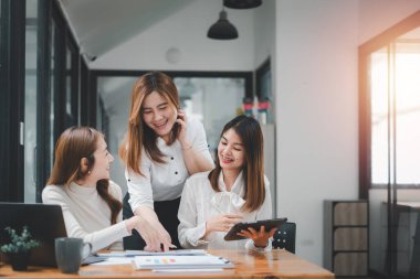 Gülümseyen çeşitli çalışanlar gülerek iş birliği yapıyor ofis ekibinin toplantısında bilgisayar üzerinde beyin fırtınası yapıyorlar. Mutlu çok ırklı iş adamları dizüstü bilgisayarda birlikte çalışıyorlar iş fikirlerini grup halinde tartışıyorlar..