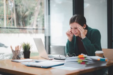 Yorgun iş kadını uykulu ve uzun süre masa başında oturmaktan sıkılmış ve ofis sendromu var.