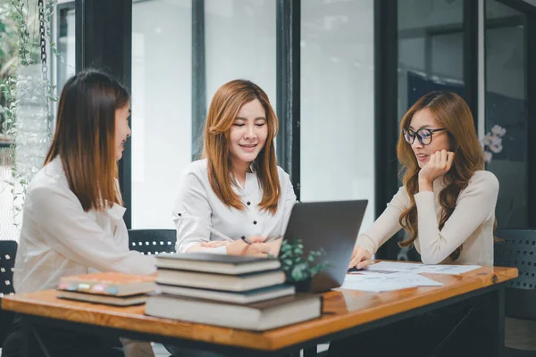 Gülümseyen çeşitli çalışanlar gülerek iş birliği yapıyor ofis ekibinin toplantısında bilgisayar üzerinde beyin fırtınası yapıyorlar. Mutlu çok ırklı iş adamları dizüstü bilgisayarda birlikte çalışıyorlar iş fikirlerini grup halinde tartışıyorlar..