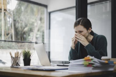 Yorgun iş kadını uykulu ve uzun süre masa başında oturmaktan sıkılmış ve ofis sendromu var.