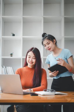 Gülümseyen çeşitli çalışanlar gülerek iş birliği yapıyor ofis ekibinin toplantısında bilgisayar üzerinde beyin fırtınası yapıyorlar. Mutlu çok ırklı iş adamları dizüstü bilgisayarda birlikte çalışıyorlar iş fikirlerini grup halinde tartışıyorlar.