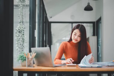 Genç başarılı beyaz iş kadınının portresi masada oturmuş dizüstü bilgisayarla çalışıyor. E-Ticaret Projesi için Hırslı Şirket Yöneticisi Yatırım Stratejisi.