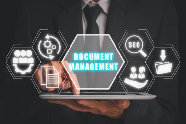 Belge yönetimi kavramı, Sanal ekranda belge yönetim simgesi ile dijital tablet kullanan İşadamı.