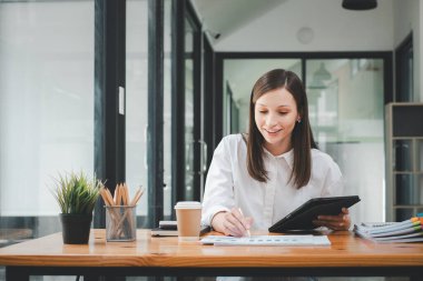 İş kadını, ofis masası, vergi, rapor, muhasebe, istatistik ve analitik araştırma kavramında matematik finansmanı için tablet ve iş kağıdı kullanıyor.