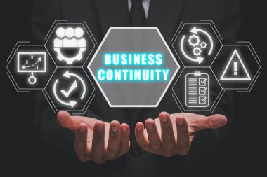 Business continuity concept, Businessman hand holding business continuity icon on virtual screen. clipart