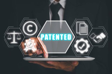 Patentli konsept, İşadamı sanal ekranda patentli simgeyle tablet bilgisayarı üzerinde çalışıyor.