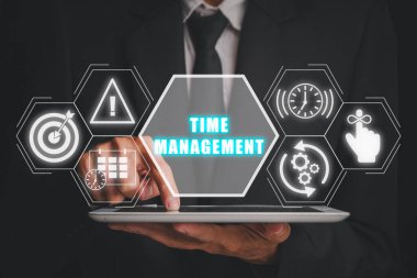 Zaman yönetimi kavramı, iş adamı sanal ekranda zaman yönetimi simgesi olan dijital tablet kullanıyor.