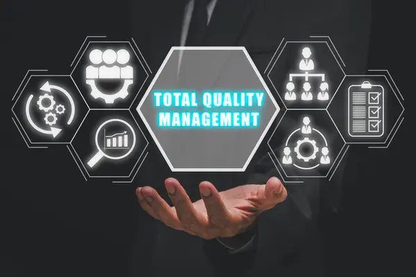 Total quality management concept, Businessman hand holding total quality management icon on virtual screen.