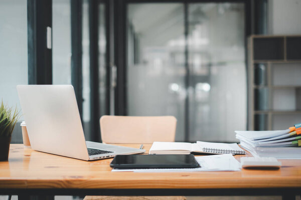 Office desk workplace with laptop and business paper on wooden table with copy space.