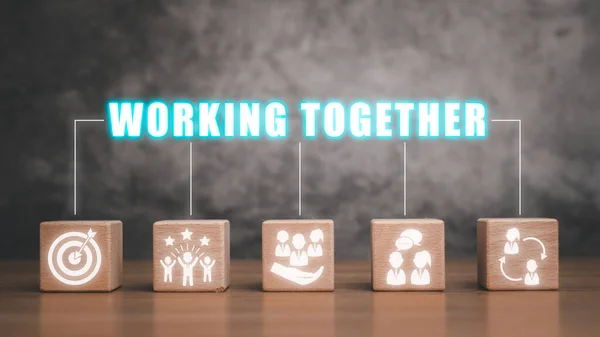 Birlikte çalışma kavramı, ahşap blok masa üzerinde sanal ekranda birlikte çalışma simgesi.
