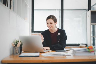 Güzel bir kadın çalıştığı yerde dizüstü bilgisayar kullanıyor. İşine odaklan..