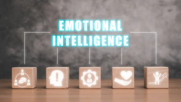 Emotional intelligence concept, Wooden block on desk with emotional intelligence icon on virtual screen.