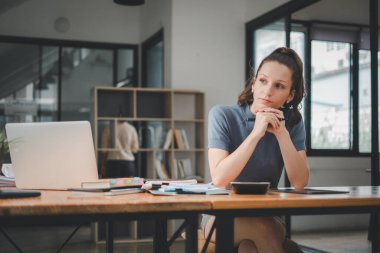 İş kadını dizüstü bilgisayar kullanıyor ve ofiste hesap makinesi ile çalışıyor, mali raporu, iş planı yatırımını, mali analiz kavramını analiz etmeyi planlıyor..