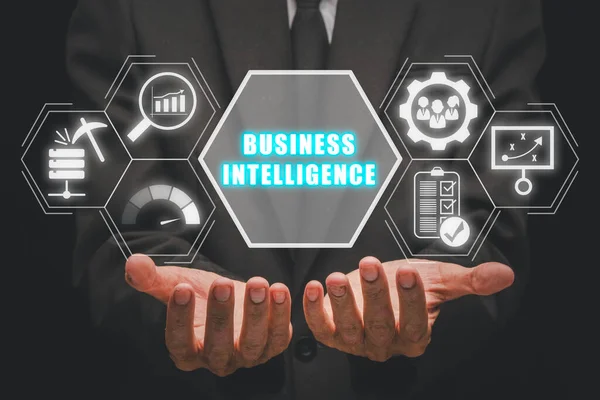 Business intelligence concept, Businessman hand holding business intelligence icon on virtual screen, data mining, analysis, Strategy, measurement, benchmarking, report and management.
