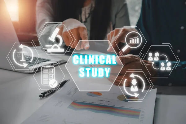 Clinical study concept, Business team using tablet computer on office desk with clinical study icon on virtual screen.