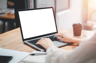 Close-up back view of a business woman working in the office typing, looking at the screen. office worker using a notebook computer.	