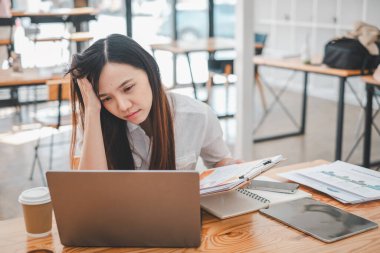 İş analizi konsepti, endişeli genç bir iş kadını bir kafede finansal raporlarını gözden geçirir..