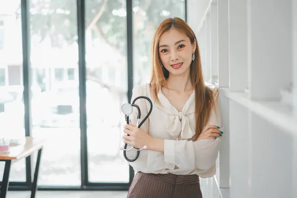 A confident healthcare professional stands poised in her clinic, stethoscope in hand, projecting a blend of competence and approachability essential in medical practice.