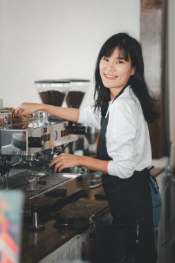 Kahve dükkanında müşteriye kahve hazırlayan güzel bir kadın..