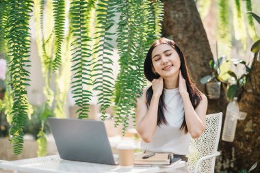 Kadın işe ara veriyor, açık hava bahçe kafesinin huzurlu ortamının tadını çıkarıyor..