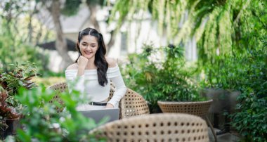 Düşünceli serbest yazar, açık havada verimli bir çalışma alanının sakinleştirici yeşiliyle çevrili olan dizüstü bilgisayarıyla karşılaşır..