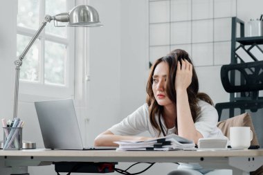 Endişeli profesyonel bakışlar, ofis çalışma alanındaki iş yükünün zorlukları üzerine kafa yormak..